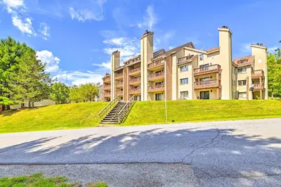 a large building on top of a grassy hill at Comfortable Dover Apartment Walk to Mt Snow! in Dover