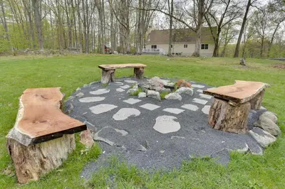a garden with two logs and two benches in a yard at Pet-Friendly Grand Pine Bush Retreat on 2 Acres! in Pine Bush