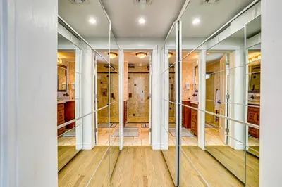 a hallway with glass doors and wood floors at Near Yale and Lighthouse Point Beach Home with Pool! in New Haven