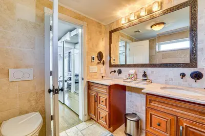a bathroom with a toilet and a sink and a mirror at Near Yale and Lighthouse Point Beach Home with Pool! in New Haven