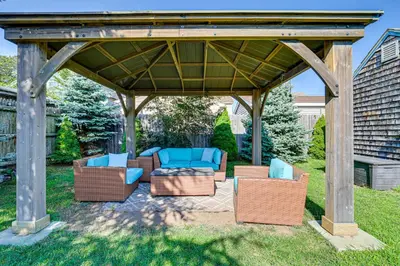 a gazebo with chairs and couches on a lawn at Near Yale and Lighthouse Point Beach Home with Pool! in New Haven