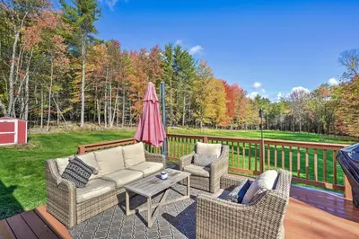 a patio with a couch and two chairs and an umbrella at Game Room and Spacious Yard 10-Acre Catskills Home! in East Durham