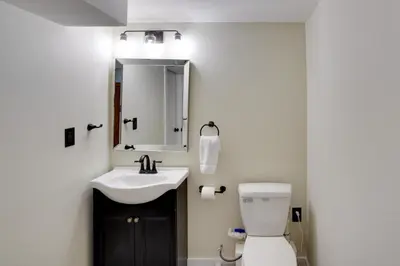 a bathroom with a sink and a toilet and a mirror at Game Room and Spacious Yard 10-Acre Catskills Home! in East Durham