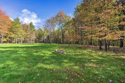 a park with a bench in the middle of a field at Game Room and Spacious Yard 10-Acre Catskills Home! in East Durham