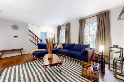 a living room with a blue couch and a rug at Tree and Easy in Tobyhanna