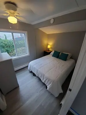 a bedroom with a large bed with a window at Beachy Bay Breeze Bungalow 2BR with parking and close to many amenities. in West Haven