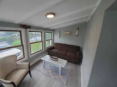 a living room with a couch and a table at Beachy Bay Breeze Bungalow 2BR with parking and close to many amenities. in West Haven