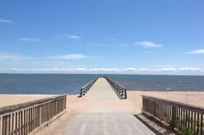 a wooden boardwalk leading to the beach with the ocean at Beachy Bay Breeze Bungalow 2BR with parking and close to many amenities. in West Haven