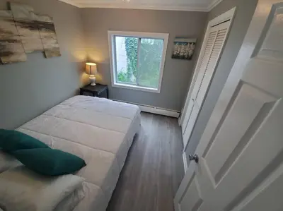 a bedroom with a large bed and a window at Beachy Bay Breeze Bungalow 2BR with parking and close to many amenities. in West Haven