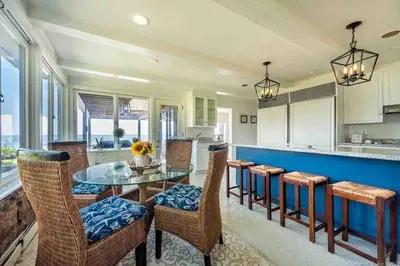 a kitchen with a glass table and chairs at Direct Waterfront 4 Bedroom Beach House With Stunning LI Sound Views & Private Beach in Guilford