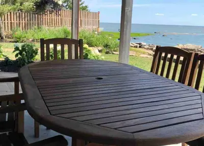 a wooden table with two chairs and a view of the ocean at Direct Waterfront 4 Bedroom Beach House With Stunning LI Sound Views & Private Beach in Guilford