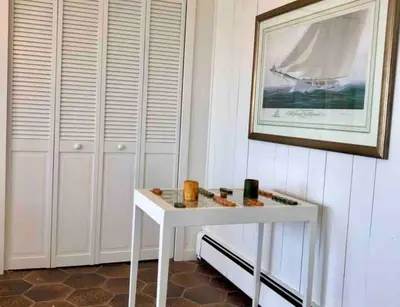 a white table in a room with a picture on the wall at Direct Waterfront 4 Bedroom Beach House With Stunning LI Sound Views & Private Beach in Guilford