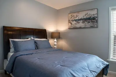 a bedroom with a bed with a blue comforter at Cozy condo with yard and patio. Long-stay discount available in Fairfield