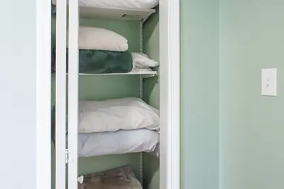 a closet with pillows and towels on shelves at Cozy condo with yard and patio. Long-stay discount available in Fairfield