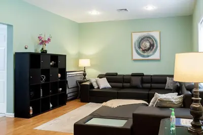 a living room with a black couch and a black cabinet at Cozy condo with yard and patio. Long-stay discount available in Fairfield