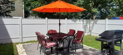 a table with chairs and an orange umbrella and a grill at Cozy condo with yard and patio. Long-stay discount available in Fairfield