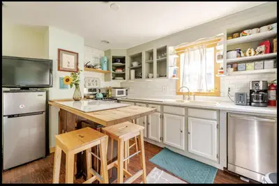 a kitchen with white cabinets and a sink and a refrigerator at 2 bedroom Apt in Kingston