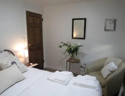 a bedroom with a white bed and a couch at 2 bedroom Apt in Kingston