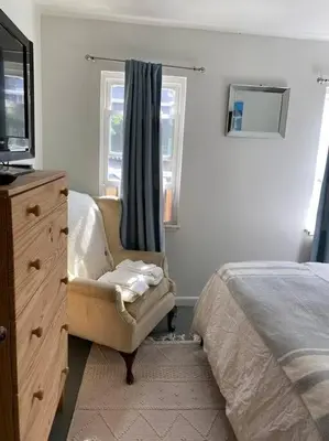 a bedroom with a bed and a chair and a dresser at 2 bedroom Apt in Kingston