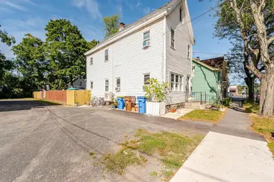 an empty street in front of a white house at 2 bedroom Apt in Kingston