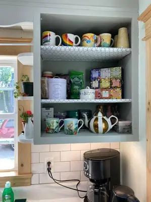 a cupboard filled with cups and mugs in a kitchen at 2 bedroom Apt in Kingston