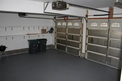 an empty garage with two stalls and two trash cans at Luxury 4 bedroom house in Pocono Mountains with Hottub in Golf Course Near Lake in Tobyhanna