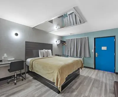 a hotel room with a large bed and a desk at Hotel OPUS Bronx Near Bay Plaza Mall in Bronx