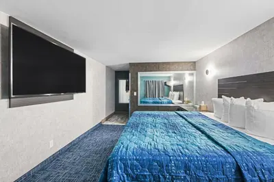 a hotel room with a large bed and a flat screen tv at Hotel OPUS Bronx Near Bay Plaza Mall in Bronx