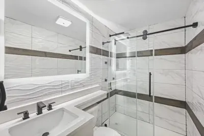 a bathroom with a shower and a toilet and a sink at Hotel OPUS Bronx Near Bay Plaza Mall in Bronx