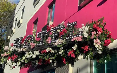 a bench filled with flowers on the side of a building at Hotel OPUS Bronx Near Bay Plaza Mall in Bronx