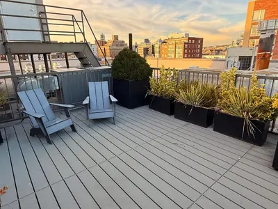 a balcony with two chairs and plants on a building at Modern Studio with Private Bathroom and Kitchen in New York