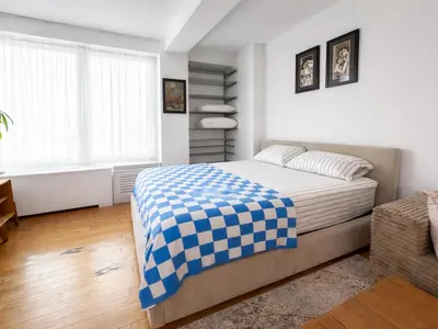 a bedroom with a bed with a blue and white checkered blanket at Modern Studio with Private Bathroom and Kitchen in New York