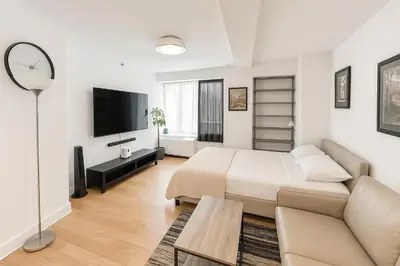 a white bedroom with a bed and a couch at Modern Studio with Private Bathroom and Kitchen in New York