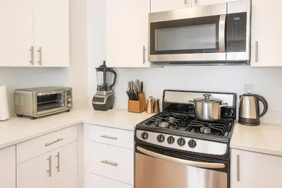 a kitchen with a stove and a microwave at Modern Studio with Private Bathroom and Kitchen in New York