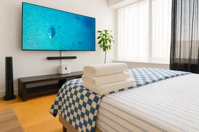 a bedroom with a bed with a tv on the wall at Modern Studio with Private Bathroom and Kitchen in New York