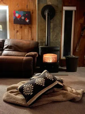a living room with a couch and a wood stove at Mandy's Mountain Chalet in Dover