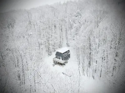 an aerial view of a house in a snow covered forest at Mandy's Mountain Chalet in Dover