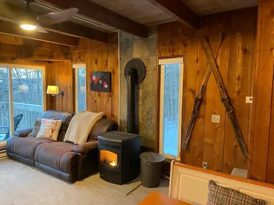 a living room with a leather couch and a wood wall at Mandy's Mountain Chalet in Dover