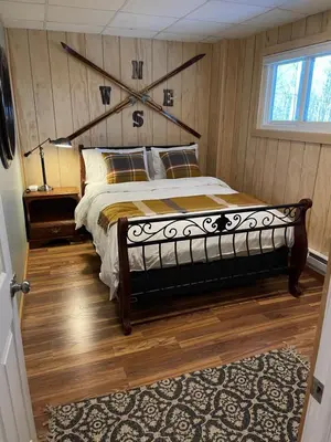 a bedroom with a large bed with a wooden floor at Mandy's Mountain Chalet in Dover