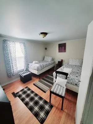 a bedroom with two beds and a table and a chair at Black-white Rm By Yale U in New Haven