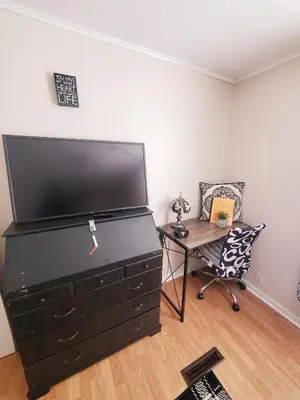 a black dresser with a desk and a chair in a room at Black-white Rm By Yale U in New Haven