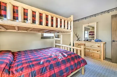 a bedroom with a bunk bed and a dresser at Deck and Forest Views Secluded Cresco Cabin! in Cresco