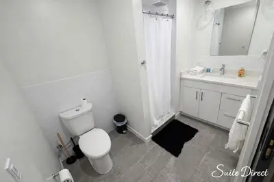 a white bathroom with a toilet and a sink at Trumbull Apartments Hartford CT in Hartford