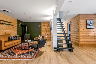 a living room with a staircase and a couch at Woodpecker House - Mountain retreat with hot tub - 10 min to skiing in Hunter & Windham in Jewett