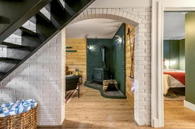 an attic room with a brick wall and a fireplace at Woodpecker House - Mountain retreat with hot tub - 10 min to skiing in Hunter & Windham in Jewett