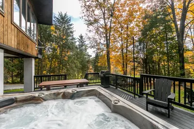 a hot tub on the deck of a house at Woodpecker House - Mountain retreat with hot tub - 10 min to skiing in Hunter & Windham in Jewett