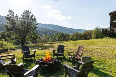 a group of chairs around a fire pit in a field at Stone Ledge in Margaretville