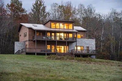 a large wooden house on a hill with trees at Stone Ledge in Margaretville