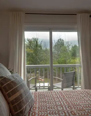 a bedroom with a bed and a large glass window at 1 Mile to Hunter Mt! Cozy 3 Bedroom in Hunter