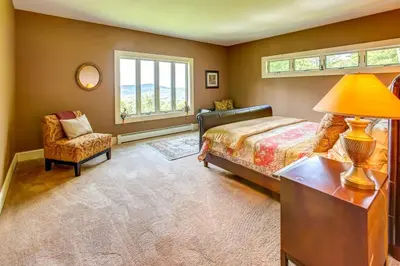a bedroom with a bed and a chair and a window at Bovina Mountain High in Bovina Center